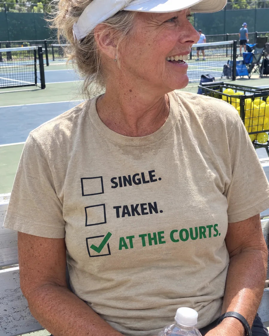 A player on a courtside bench in a sand At The Courts tee