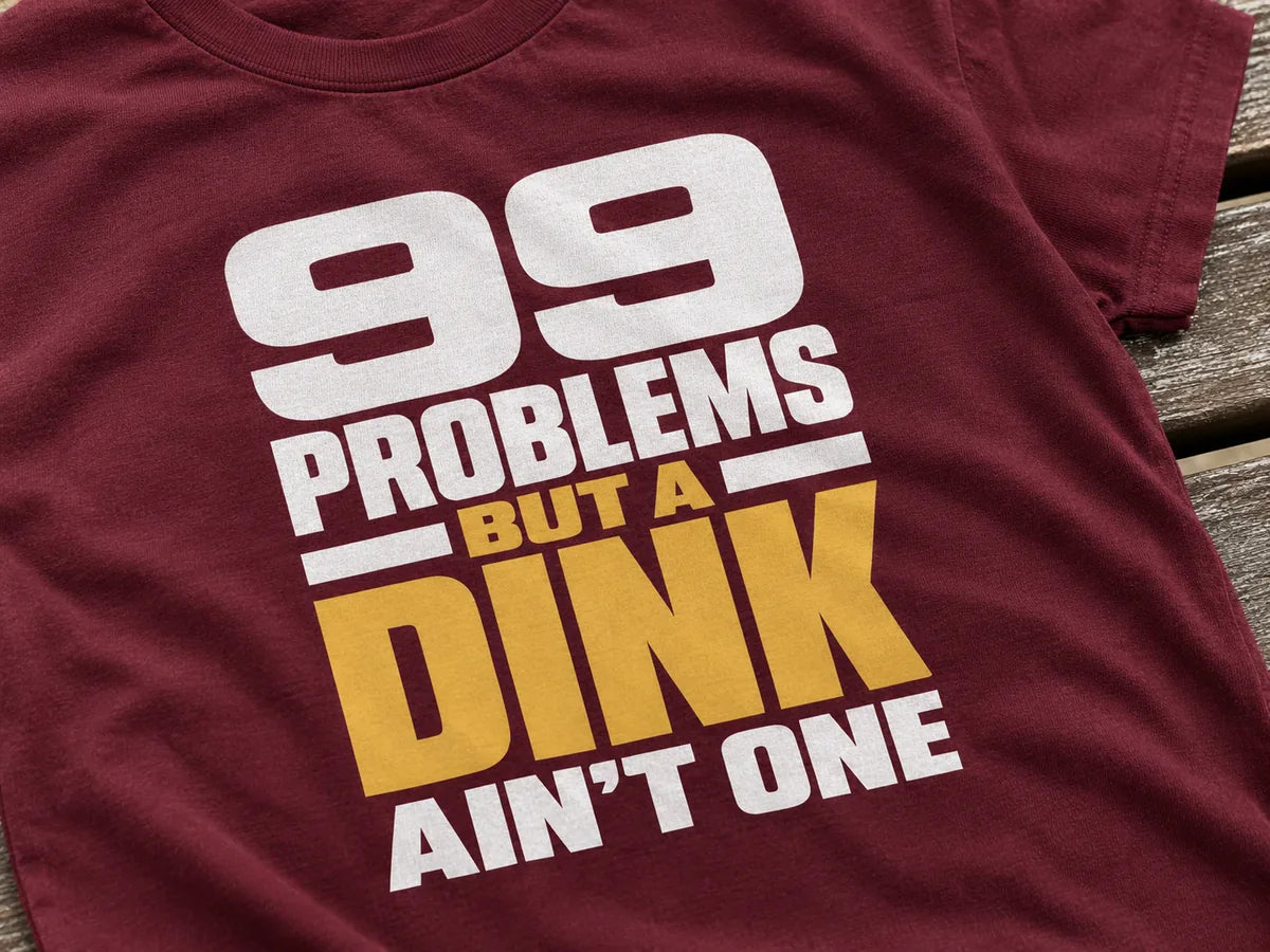 Close-up of a maroon tee with a white and gold 99 Problems print